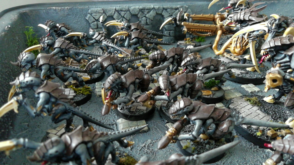Showcase Foto Warhammer 40k Tyranid Army Miniatures, painted, on Ruined City Bases. Die Minis sind zur Aufbewahrung magnetisch in einem dekorierten Backblech angeordnet.