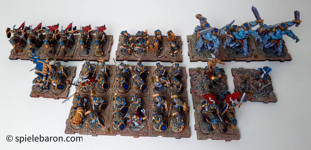 Showcase Runewars Tabletop Daqan Armee, bemalt: Farbschema: Blau-Gold-Rot vor weißem Hintergrund