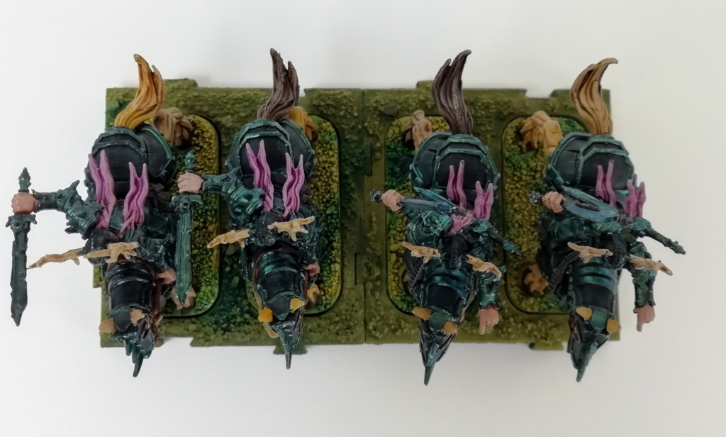 Showcase Runewars Tabletop Miniaturen: Untote Waiqar Skelett Armee: Todesritter, bemalt im Farbschema Blau-Metallic und Violett auf grünen Bases
