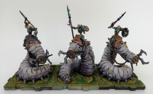 Showcase Runewars Tabletop Miniaturen: Untote Waiqar Skelett Armee: Aasreiter, bemalt im Farbschema Blau-Metallic und Violett auf grünen Bases