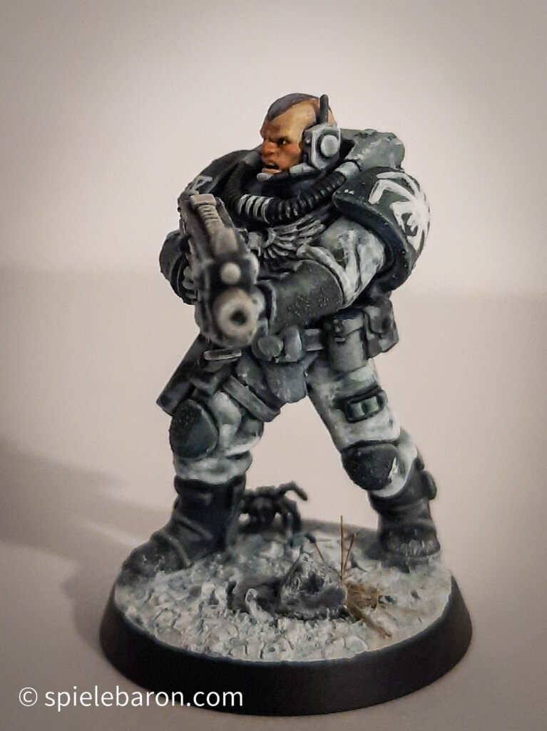 Foto eines Space Marine Primaris Scouts mit Boltgewehr in Winter-Camouflage, bemalt mit Winterbase vor weißem Hintergrund; schräg frontal