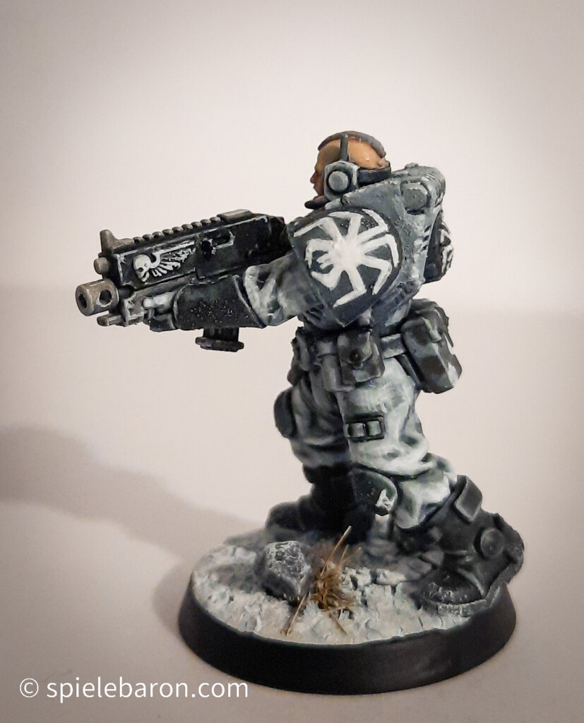 Foto eines Space Marine Primaris Scouts mit Boltgewehr in Winter-Camouflage, bemalt mit Winterbase vor weißem Hintergrund; setilich