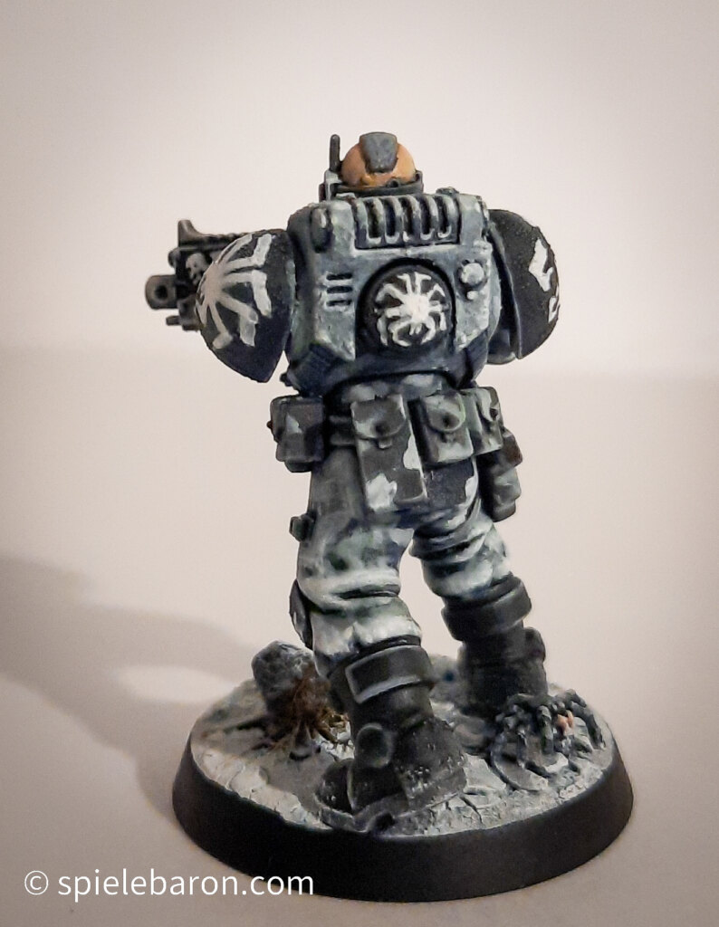 Foto eines Space Marine Primaris Scouts mit Boltgewehr in Winter-Camouflage, bemalt mit Winterbase vor weißem Hintergrund; von hinten