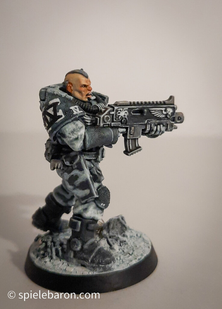 Foto eines Space Marine Primaris Scouts mit Boltgewehr in Winter-Camouflage, bemalt mit Winterbase vor weißem Hintergrund; seitlich