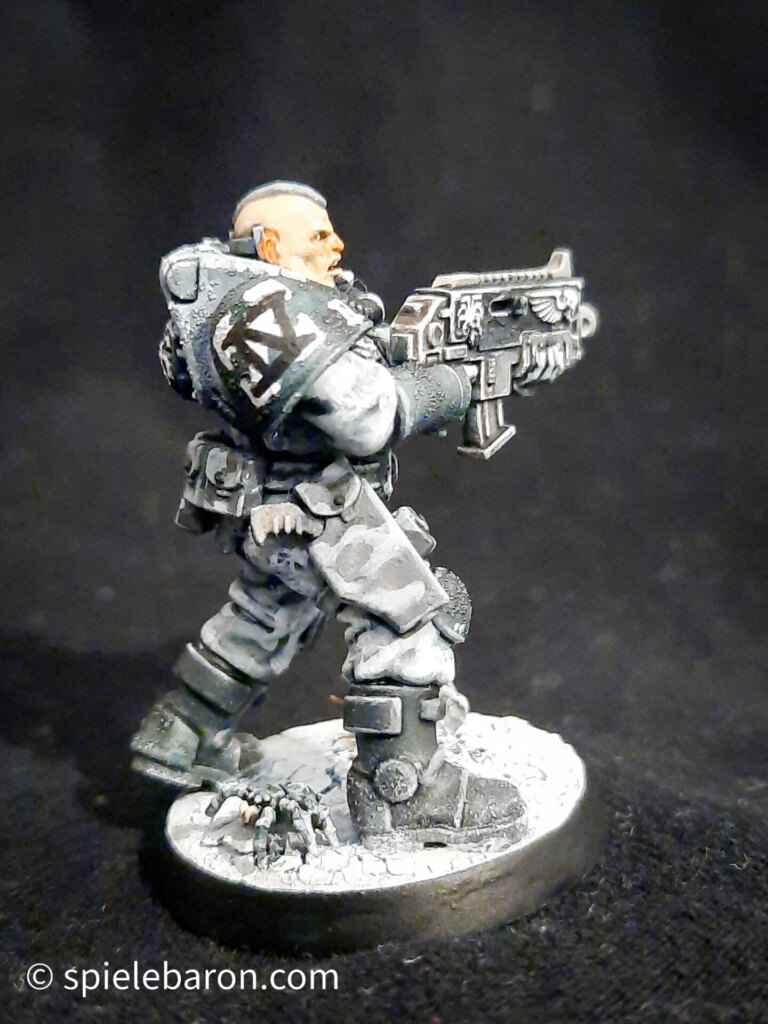 Foto eines Space Marine Primaris Scouts mit Boltgewehr in Winter-Camouflage, bemalt mit Winterbase vor schwarzem Hintergrund; seitlich