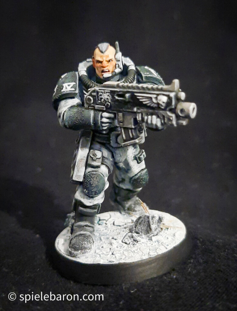 Foto eines Space Marine Primaris Scouts mit Boltgewehr in Winter-Camouflage, bemalt mit Winterbase vor schwarzem Hintergrund; frontal